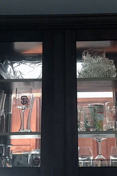 Glassed display case with collectible glassware